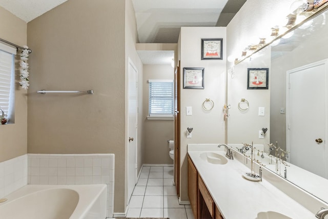 bathroom featuring double vanity, toilet, a bath, tile patterned floors, and a sink