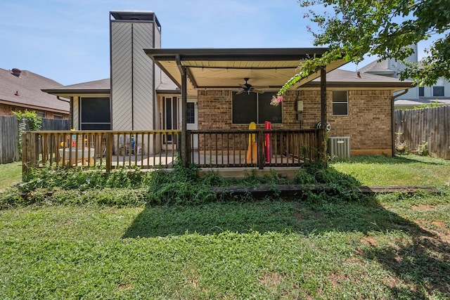back of house with fence, a wooden deck, a ceiling fan, central AC unit, and a lawn