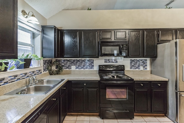 kitchen featuring a sink, light tile patterned floors, lofted ceiling, tasteful backsplash, and black appliances