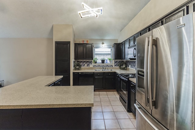 kitchen with tasteful backsplash, vaulted ceiling, a sink, light countertops, and black appliances