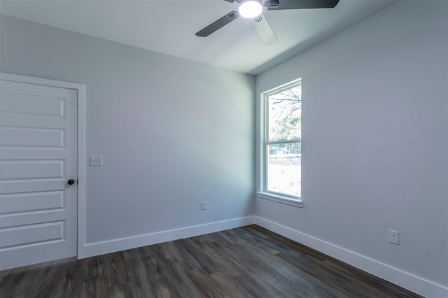 empty room featuring baseboards, ceiling fan, a wealth of natural light, and dark wood-style floors