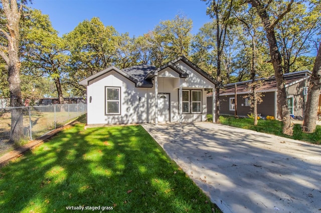 view of front of house with fence, driveway, and a front yard