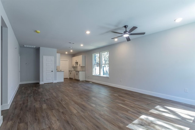 unfurnished living room with baseboards, ceiling fan, and dark wood-style floors