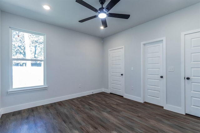 unfurnished bedroom featuring two closets, baseboards, ceiling fan, dark wood-type flooring, and recessed lighting