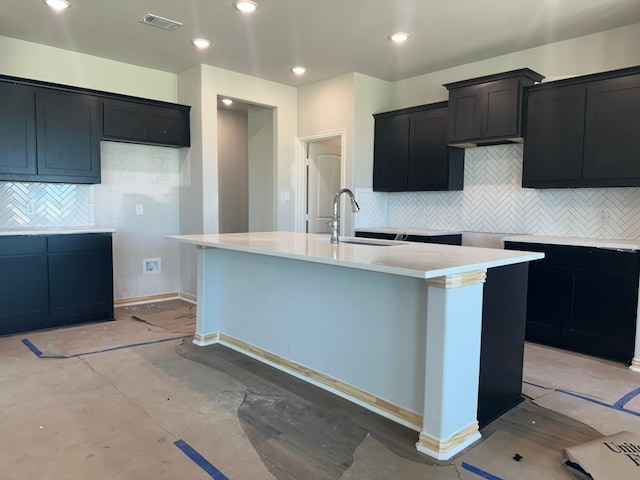 2471 Blackjack Oak Rd, Oak Ridge, TX 75161 - kitchen featuring a sink, a kitchen island with sink, decorative backsplash, dark cabinetry, and recessed lighting