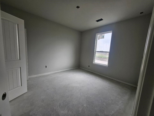empty room with baseboards and concrete flooring