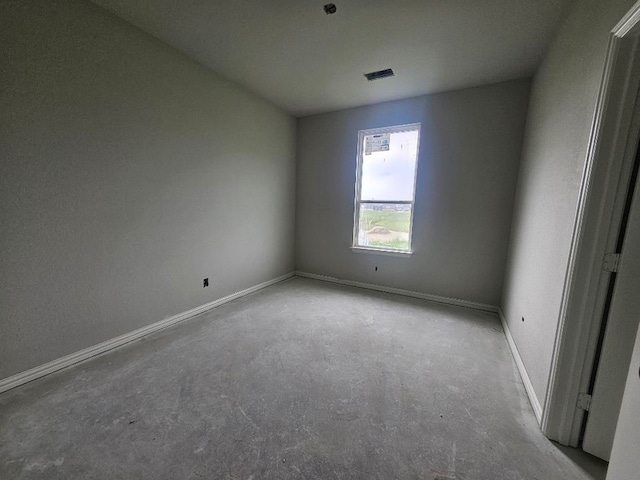 spare room featuring baseboards, visible vents, and unfinished concrete flooring