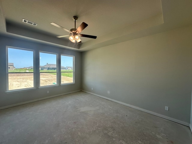 2471 Blackjack Oak Rd, Oak Ridge, TX 75161 - spare room with a raised ceiling, baseboards, a ceiling fan, unfinished concrete flooring, and a textured ceiling