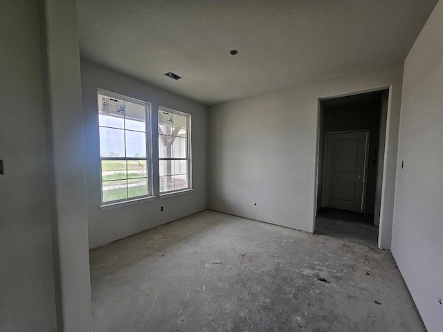 empty room featuring visible vents and unfinished concrete flooring
