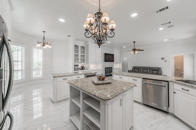 kitchen with dishwasher, a chandelier, a kitchen island, light marble finish floors, and freestanding refrigerator