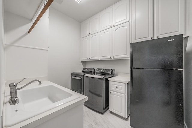laundry area featuring cabinet space, washer and clothes dryer, and light marble finish flooring