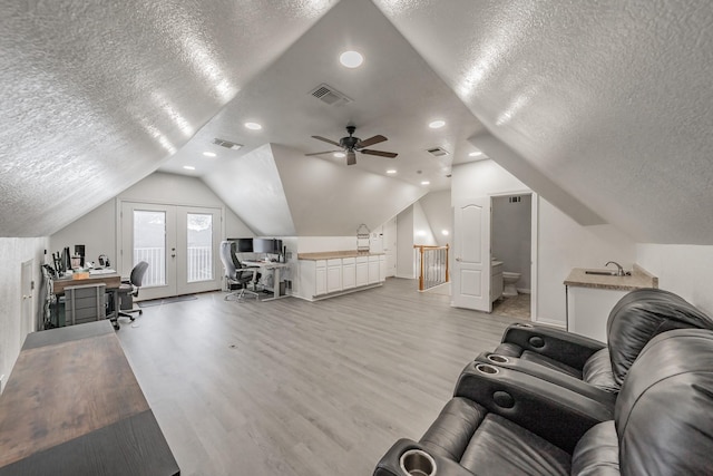 bedroom featuring a textured ceiling, a desk, light wood-style floors, a sink, and access to outside