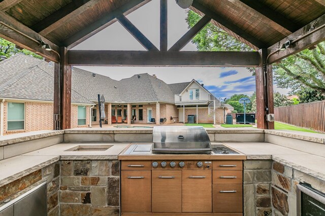 view of patio with area for grilling, fence, a gazebo, and wine cooler