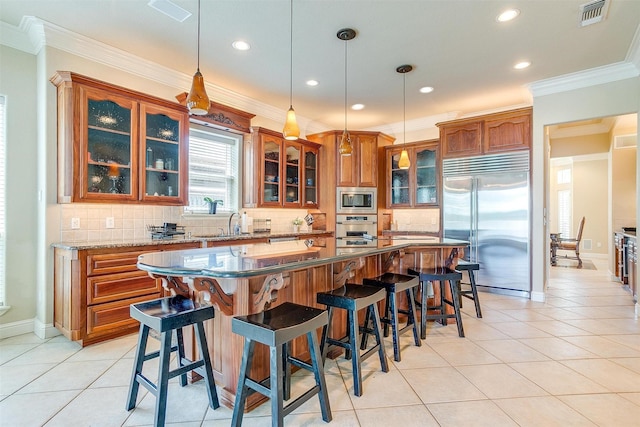 kitchen featuring visible vents, decorative backsplash, built in appliances, brown cabinets, and light tile patterned floors