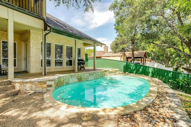 view of swimming pool featuring a fenced in pool, a fenced backyard, and a patio area