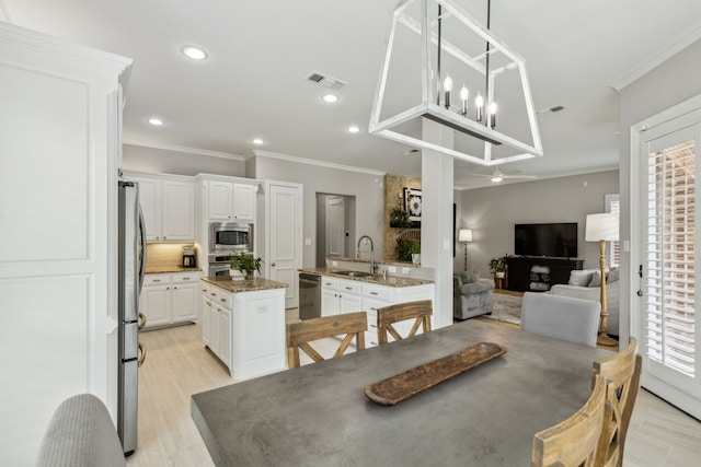 7913 Craftsbury Ln, Mckinney, TX 75071 - kitchen with stainless steel appliances, a sink, a center island, white cabinetry, and recessed lighting