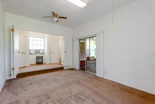unfurnished living room featuring a ceiling fan, a textured ceiling, baseboards, and carpet