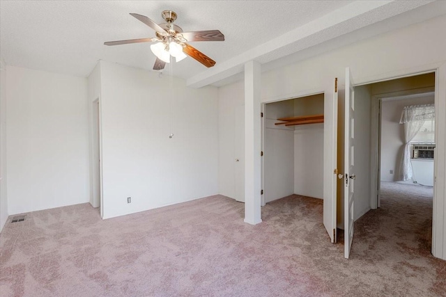 unfurnished bedroom with ceiling fan, light colored carpet, visible vents, and a closet