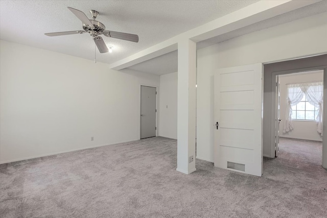 carpeted empty room with a ceiling fan and a textured ceiling