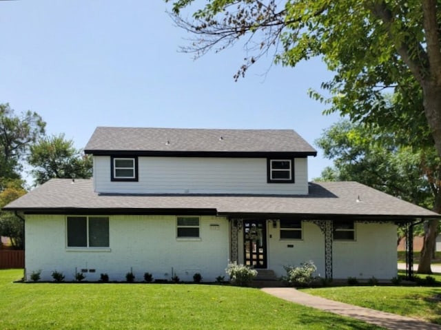 traditional-style house featuring brick siding, roof with shingles, and a front lawn