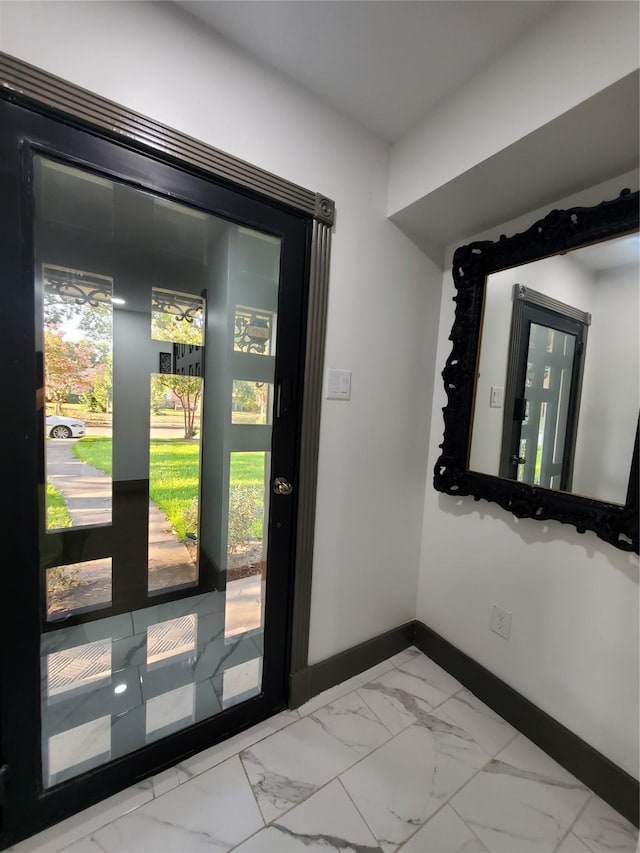 foyer entrance with baseboards and marble finish floor