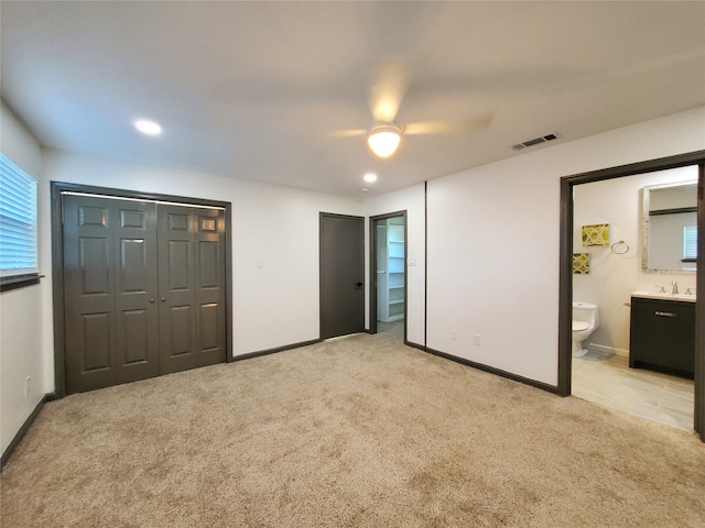 unfurnished bedroom featuring two closets, baseboards, light colored carpet, and visible vents