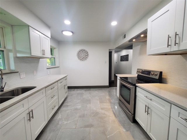 kitchen featuring a sink, light countertops, decorative backsplash, and stainless steel range with electric cooktop