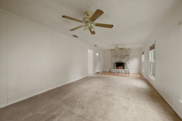 unfurnished living room with ceiling fan, carpet, a textured ceiling, and visible vents
