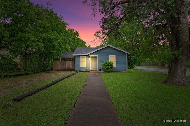 view of front of home featuring fence and a yard
