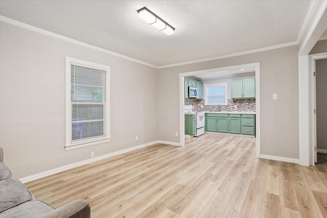 unfurnished living room featuring baseboards, a textured ceiling, ornamental molding, and light wood-style flooring