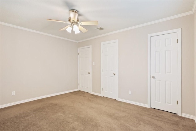 unfurnished bedroom with ceiling fan, carpet floors, baseboards, visible vents, and ornamental molding