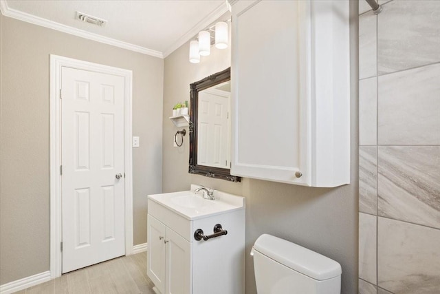 bathroom featuring visible vents, ornamental molding, vanity, toilet, and baseboards