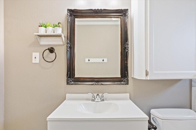half bathroom featuring vanity and toilet