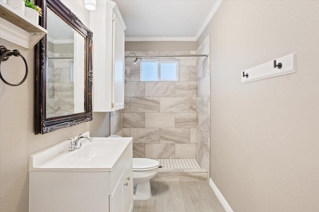 bathroom featuring vanity, crown molding, toilet, baseboards, and a stall shower