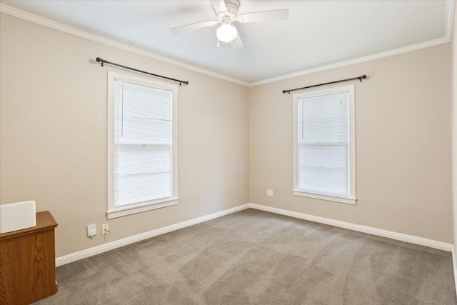 carpeted empty room with baseboards, ornamental molding, and a ceiling fan