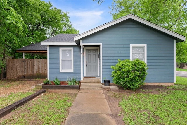 bungalow featuring roof with shingles and fence