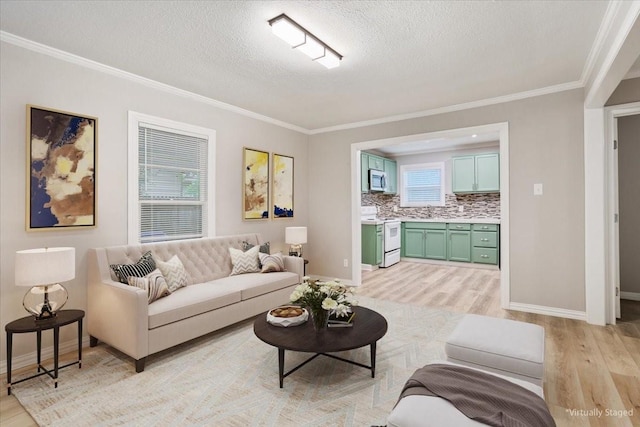 living area featuring a textured ceiling, ornamental molding, baseboards, and light wood-style flooring