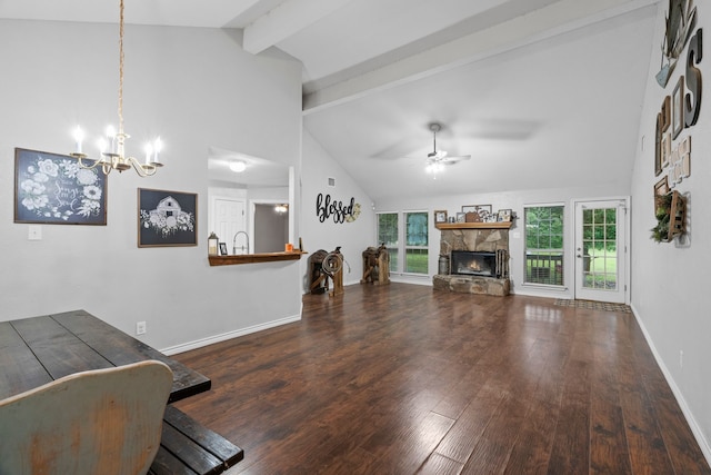 unfurnished living room with beam ceiling, wood finished floors, baseboards, a stone fireplace, and ceiling fan with notable chandelier