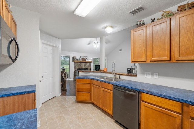 kitchen with visible vents, black microwave, stainless steel dishwasher, a fireplace, and a sink