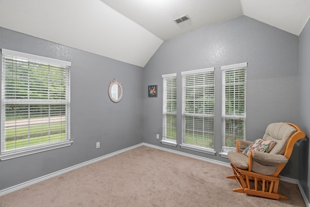 living area featuring carpet floors, baseboards, visible vents, and lofted ceiling