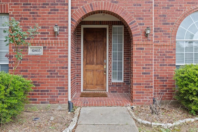 property entrance featuring brick siding