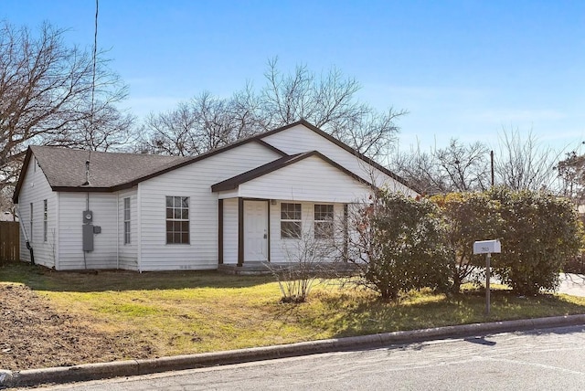 bungalow-style house with roof with shingles, fence, and a front yard