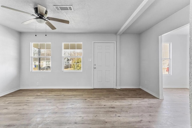 unfurnished room featuring ceiling fan, a textured ceiling, baseboards, wood finished floors, and visible vents