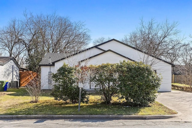 view of property exterior featuring concrete driveway, fence, and central AC unit