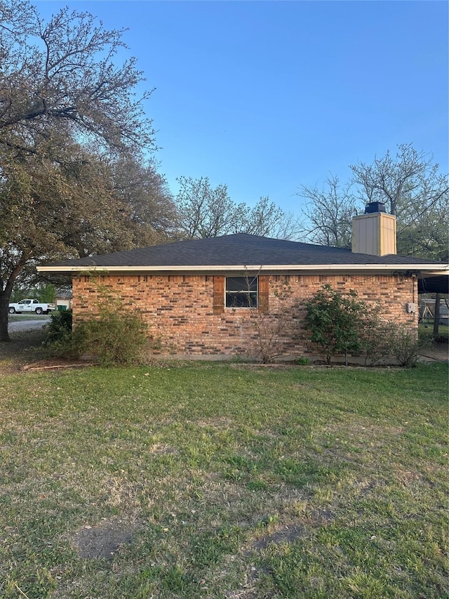 202 S Spencer St, Mart, TX 76664 - view of property exterior featuring a lawn, brick siding, and a chimney