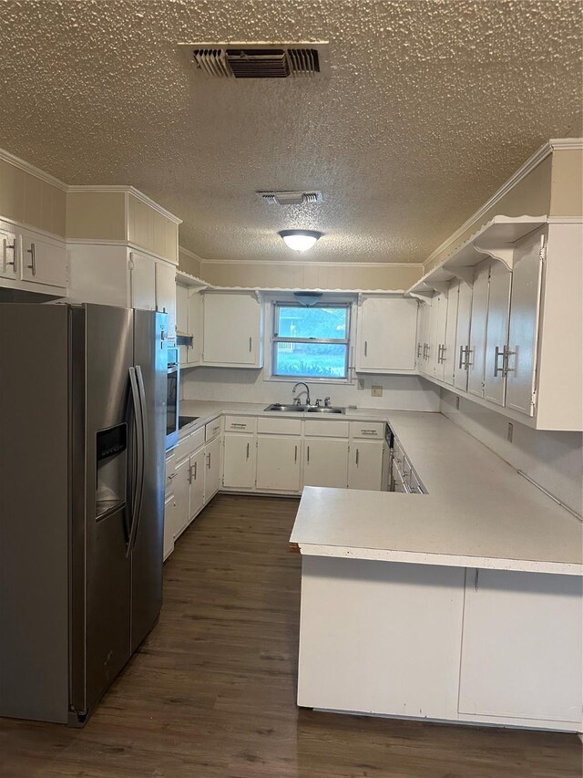 202 S Spencer St, Mart, TX 76664 - kitchen with dark wood-style flooring, a sink, stainless steel fridge with ice dispenser, a peninsula, and visible vents
