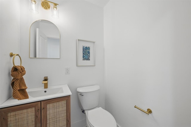 half bath featuring toilet, baseboards, and vanity