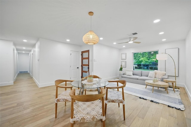 dining space with baseboards, light wood-type flooring, and visible vents