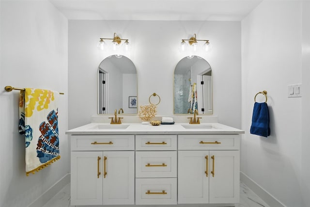 bathroom featuring double vanity, baseboards, a sink, and marble finish floor