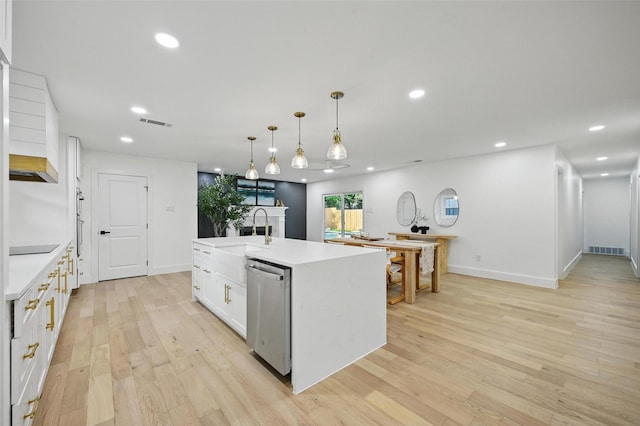kitchen featuring white cabinets, a sink, light countertops, light wood-type flooring, and visible vents